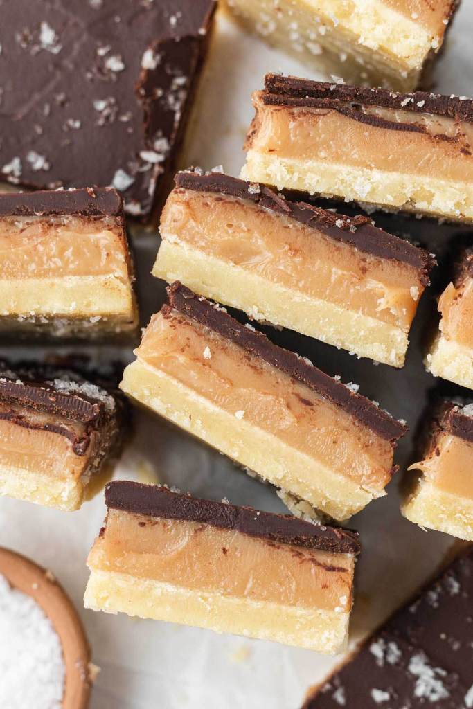 A close up, overhead view of caramel shortbread bars sliced and turned on their sides. 