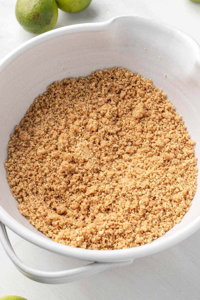 Graham cracker crumb mixture in a white mixing bowl.