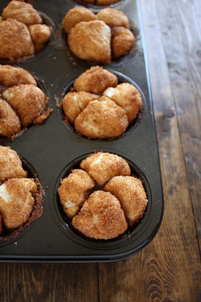 A pan of baked Monkey Bread Muffins on a wood surface. 