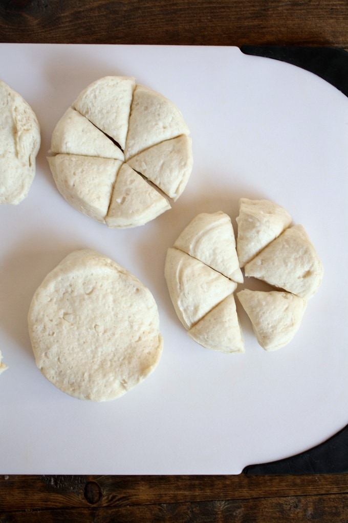 Overhead view of raw biscuit dough on a cutting board. 