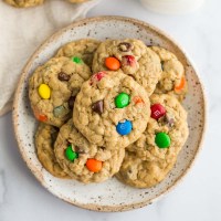 A stack of monster cookies on a speckled plate.