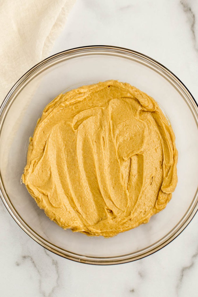 A glass bowl with the wet ingredients for monster cookies mixed together.