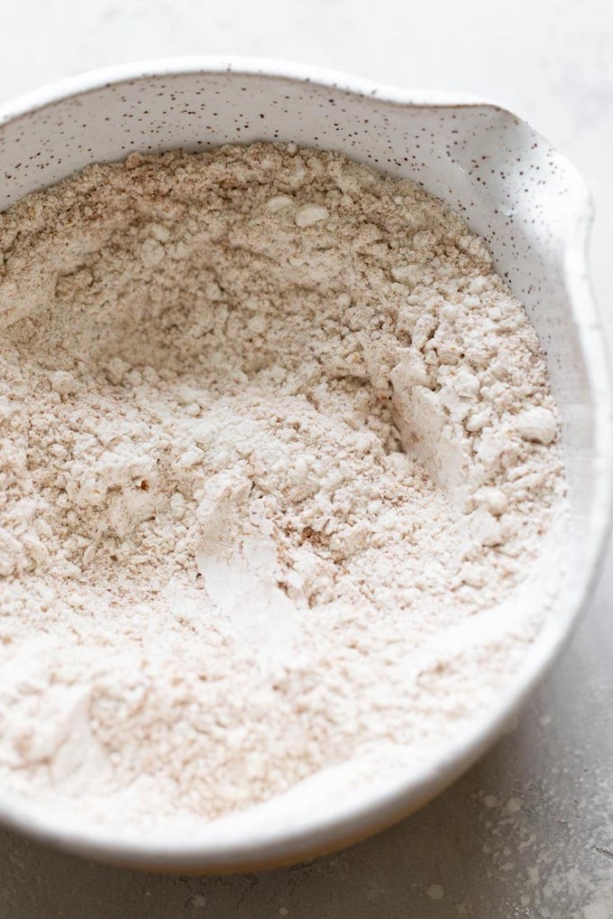 Overhead view of dry ingredients for muffins in a white mixing bowl.