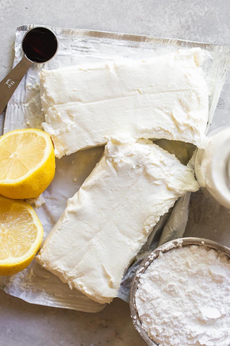 The ingredients needed to make the no-bake cheesecake filling on a rustic gray surface.