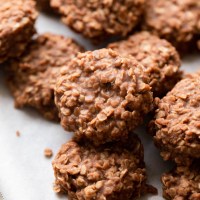 Several no-bake cookies on a piece of parchment paper.