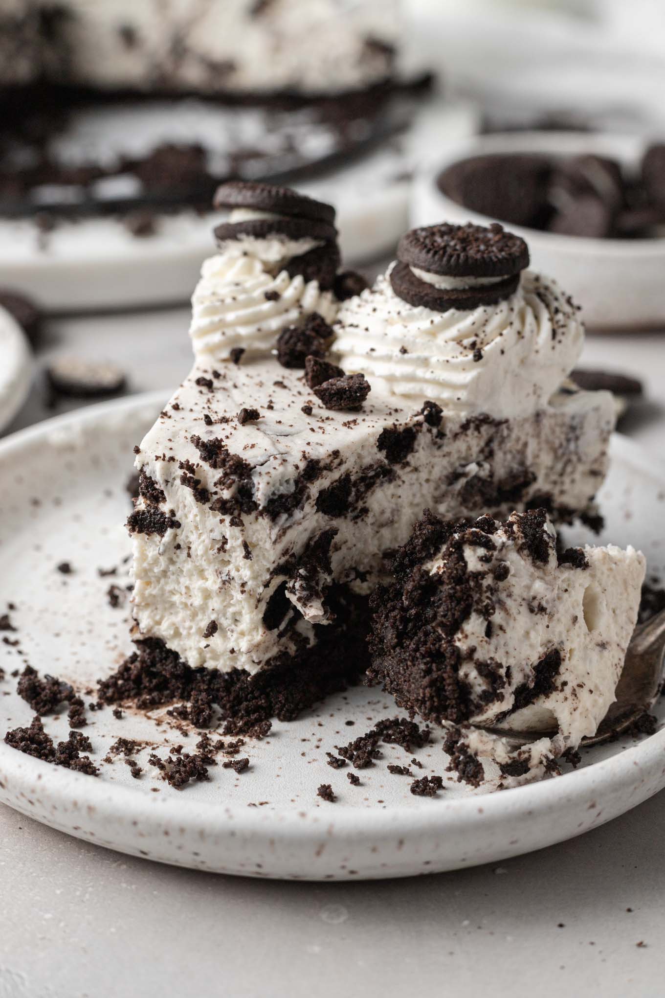 A slice of no bake Oreo cheesecake, with a bite missing. 