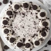 An overhead view of a no-bake Oreo cheesecake topped with whipped cream and mini Oreos.