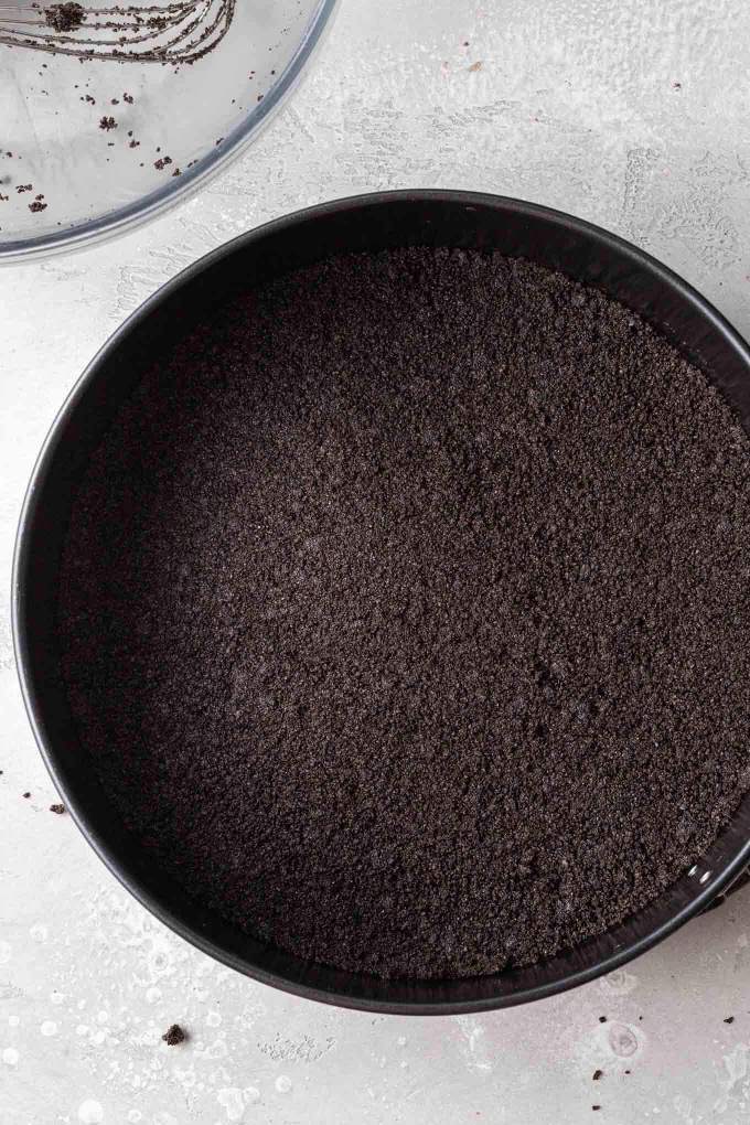 An Oreo crust pressed into a springform pan.