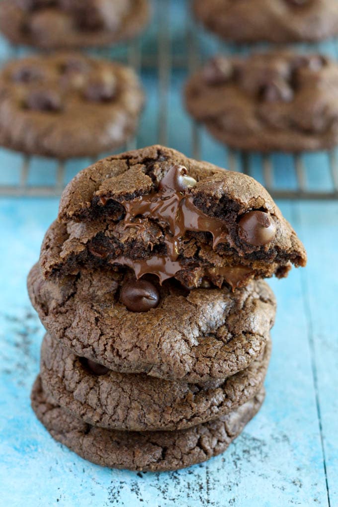 A stack of four nutella stuffed cookies. Additional cookies rest on a cooling rack in the background. 