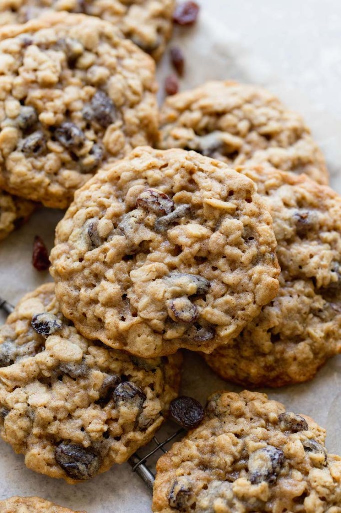 Several oatmeal raisin cookies on top of a piece of parchment paper.