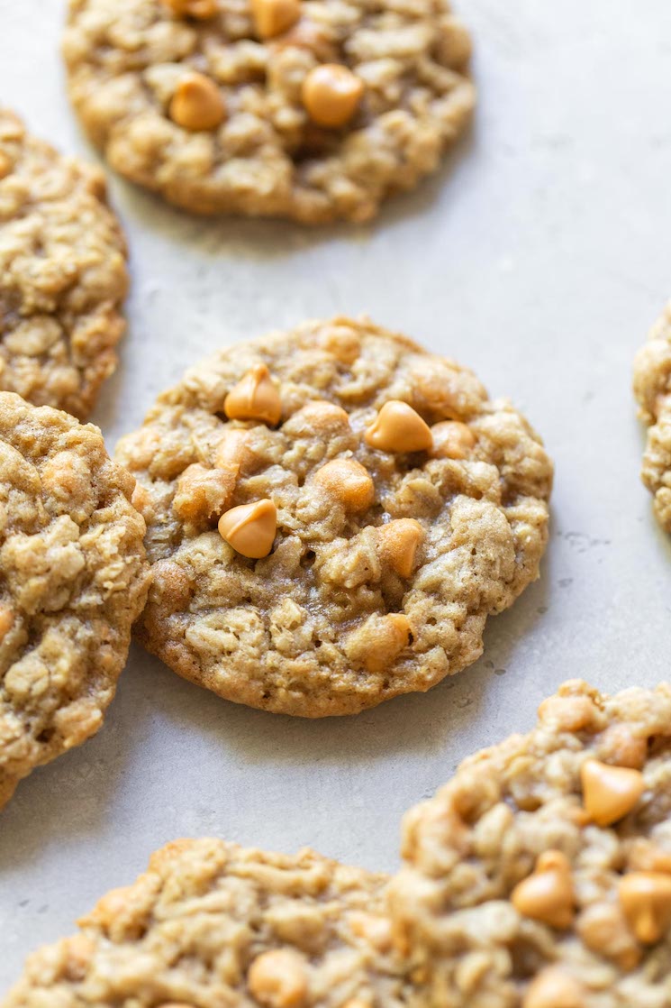 Baked oatmeal scotchies scattered on a rustic gray surface. 