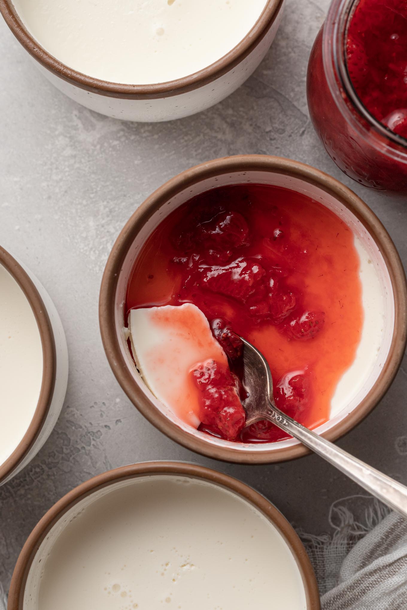 An overhead view of strawberry panna cotta in ramekins. 