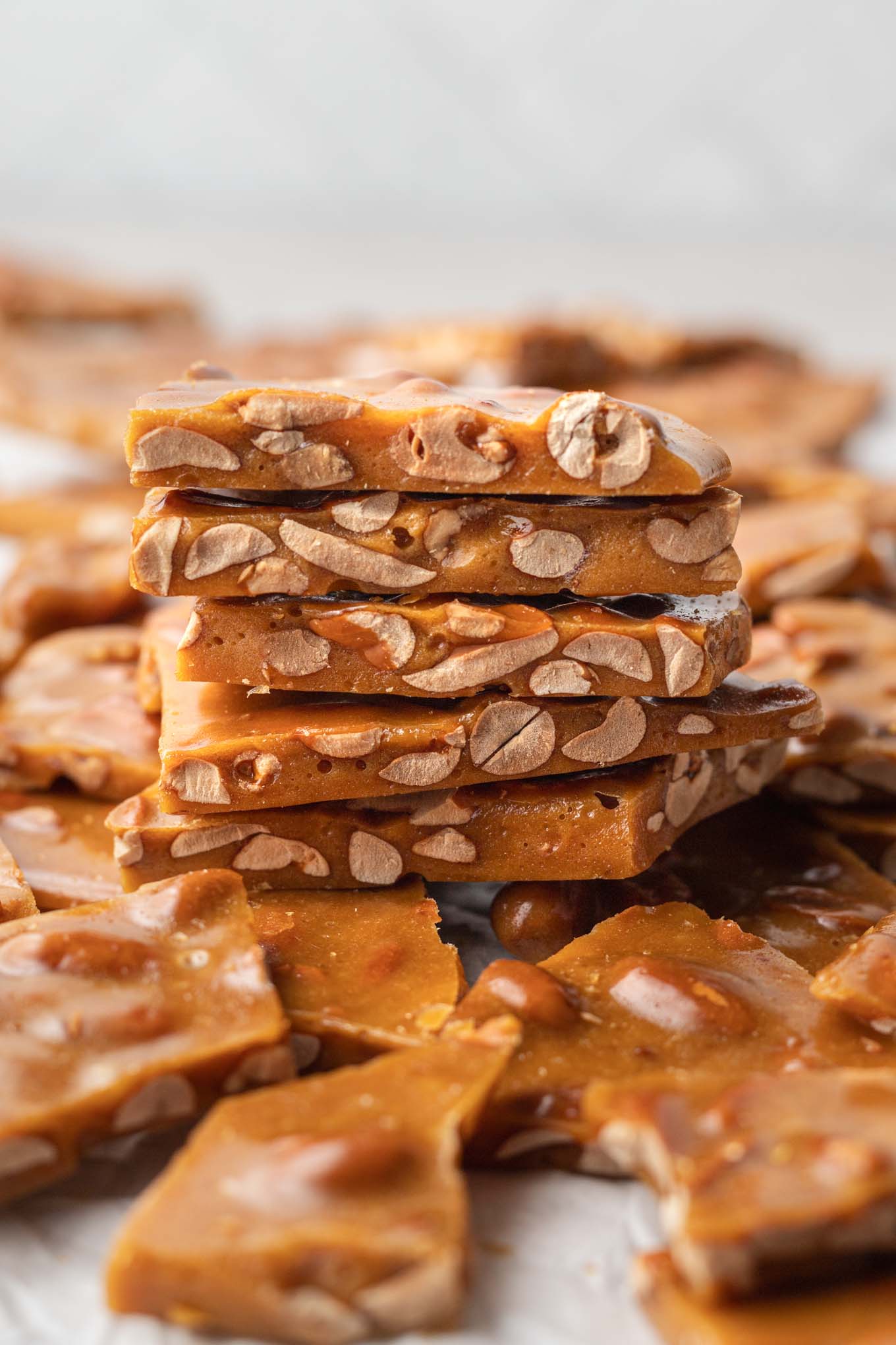 A stack of buttery homemade peanut brittle, seen from the side. 