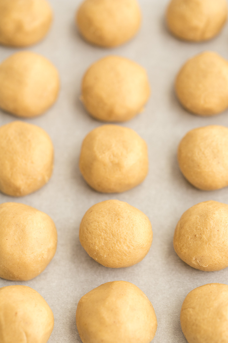 A baking sheet lined with the rolled peanut butter mixture.