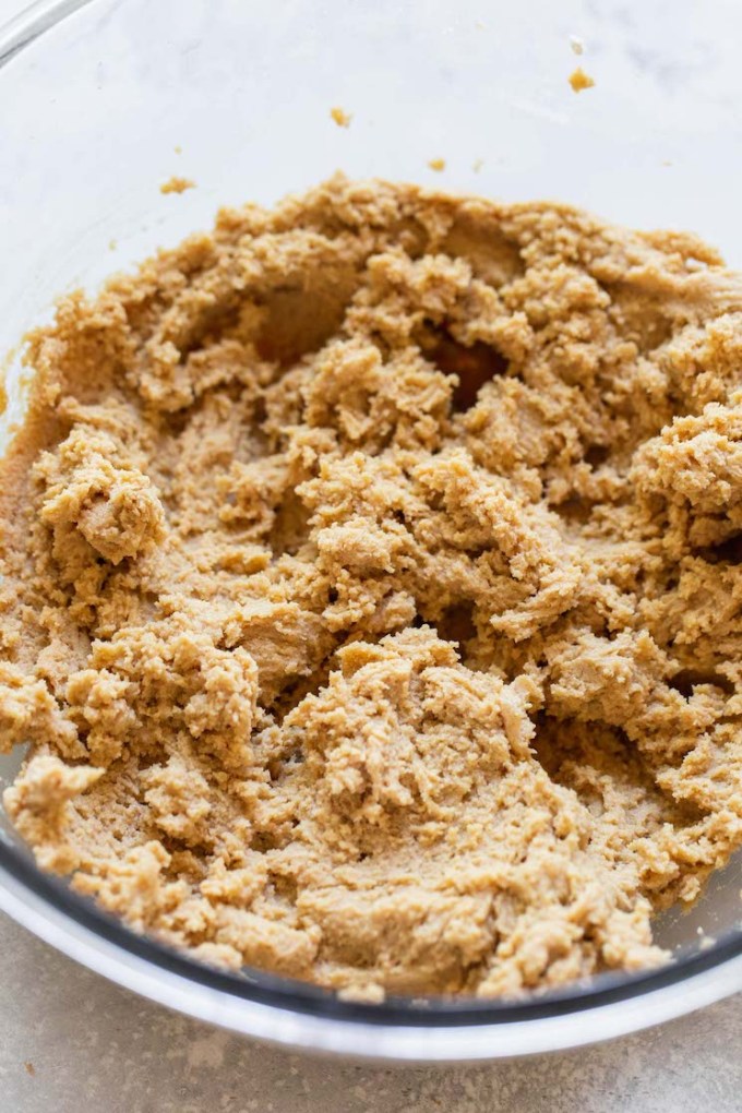 Peanut butter cookie dough mixed up in a glass bowl.