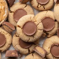 Several peanut butter cup cookies on a piece of parchment paper.