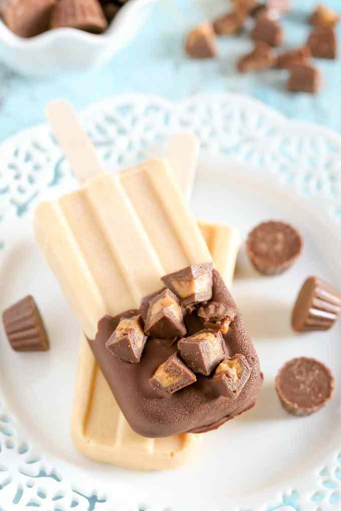 Peanut butter popsicles topped with magic shell and mini peanut butter cups. These Peanut Butter Cup Pudding Pops are a delicious and easy summer treat!