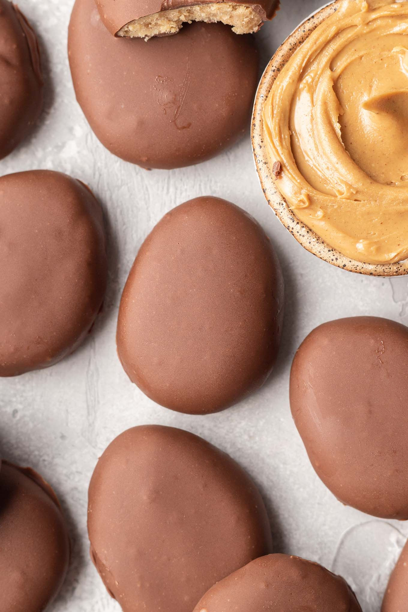 An overhead view of peanut butter Easter eggs with a dish of peanut butter. 