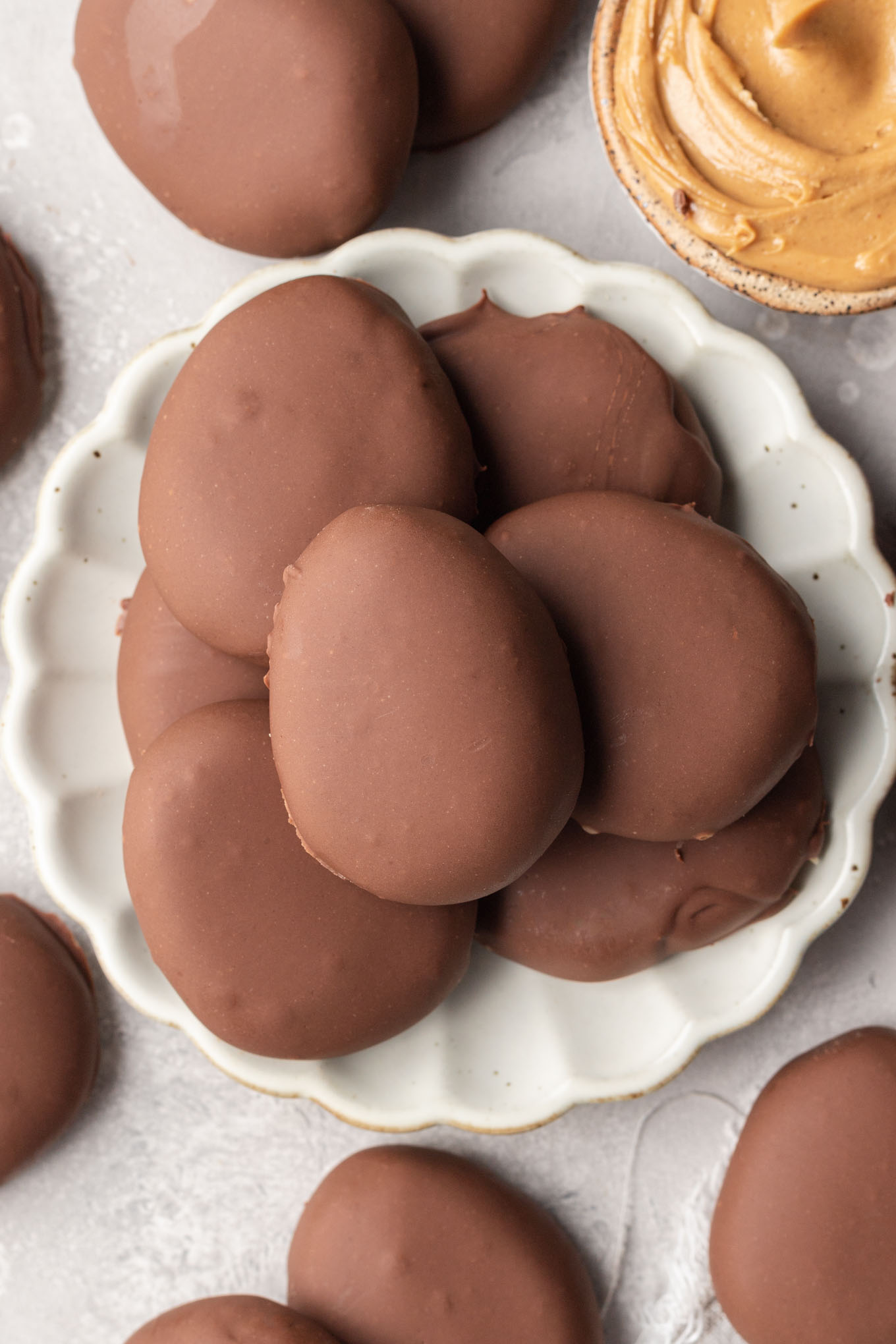 An overhead view of homemade peanut butter eggs on a white plate. 