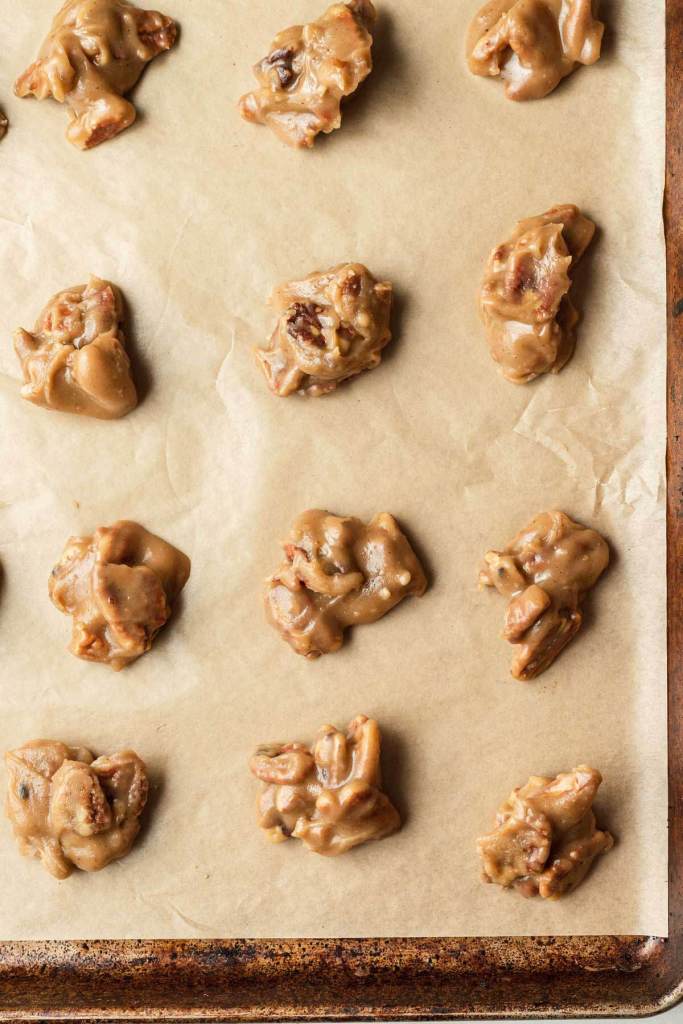 An overhead view of soft pralines on a parchment-lined baking sheet. 