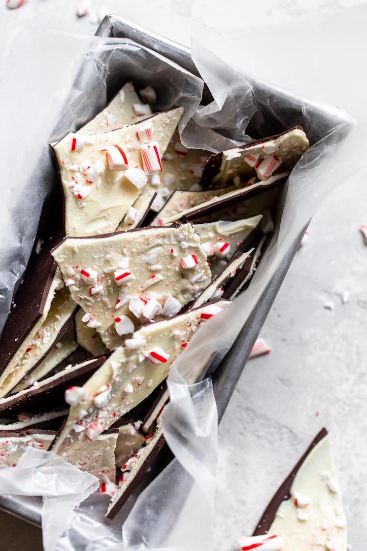 A metal loaf pan with pieces of peppermint bark topped with crushed candy canes.