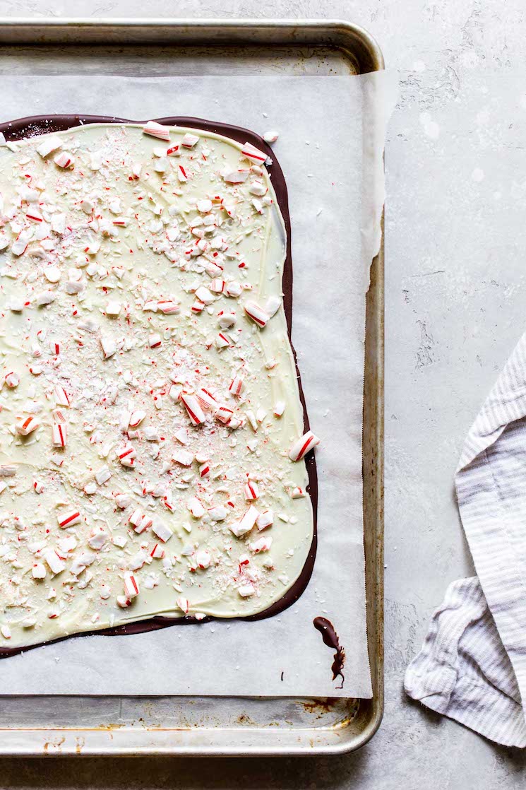 A finished batch of peppermint bark on top of a metal baking pan lined with parchment paper. 