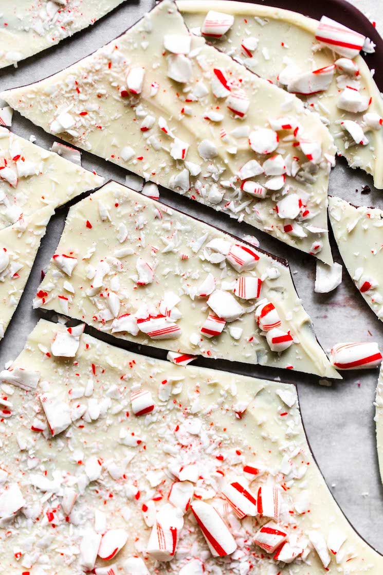 A pan filled with pieces of peppermint bark topped with crushed candy canes. 