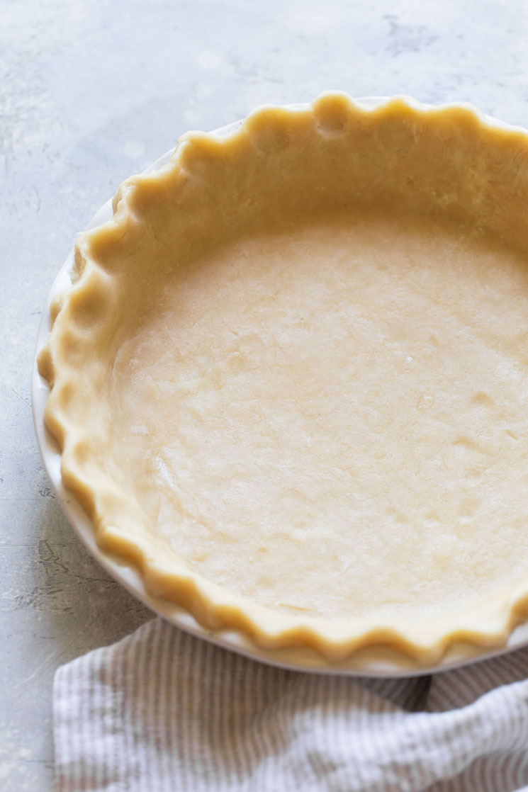 A finished unbaked pie crust showing the decorated edge.