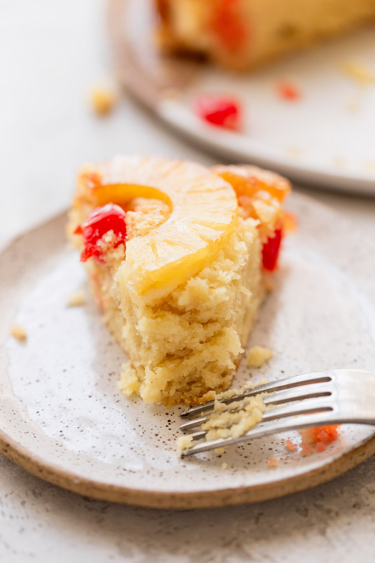 A single piece of cake on a plate with a bite taken out of it.