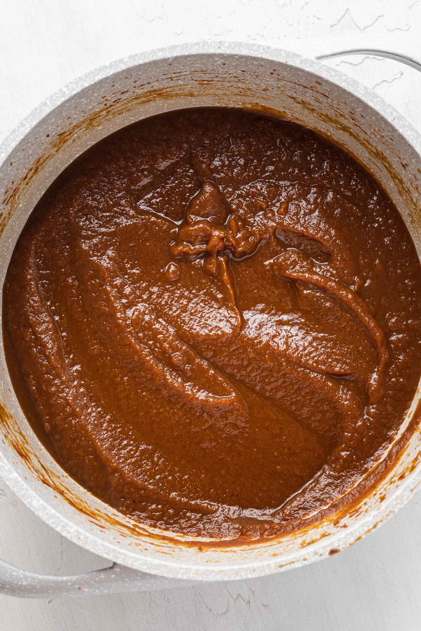 An overhead view of thickened pumpkin butter in a saucepan.