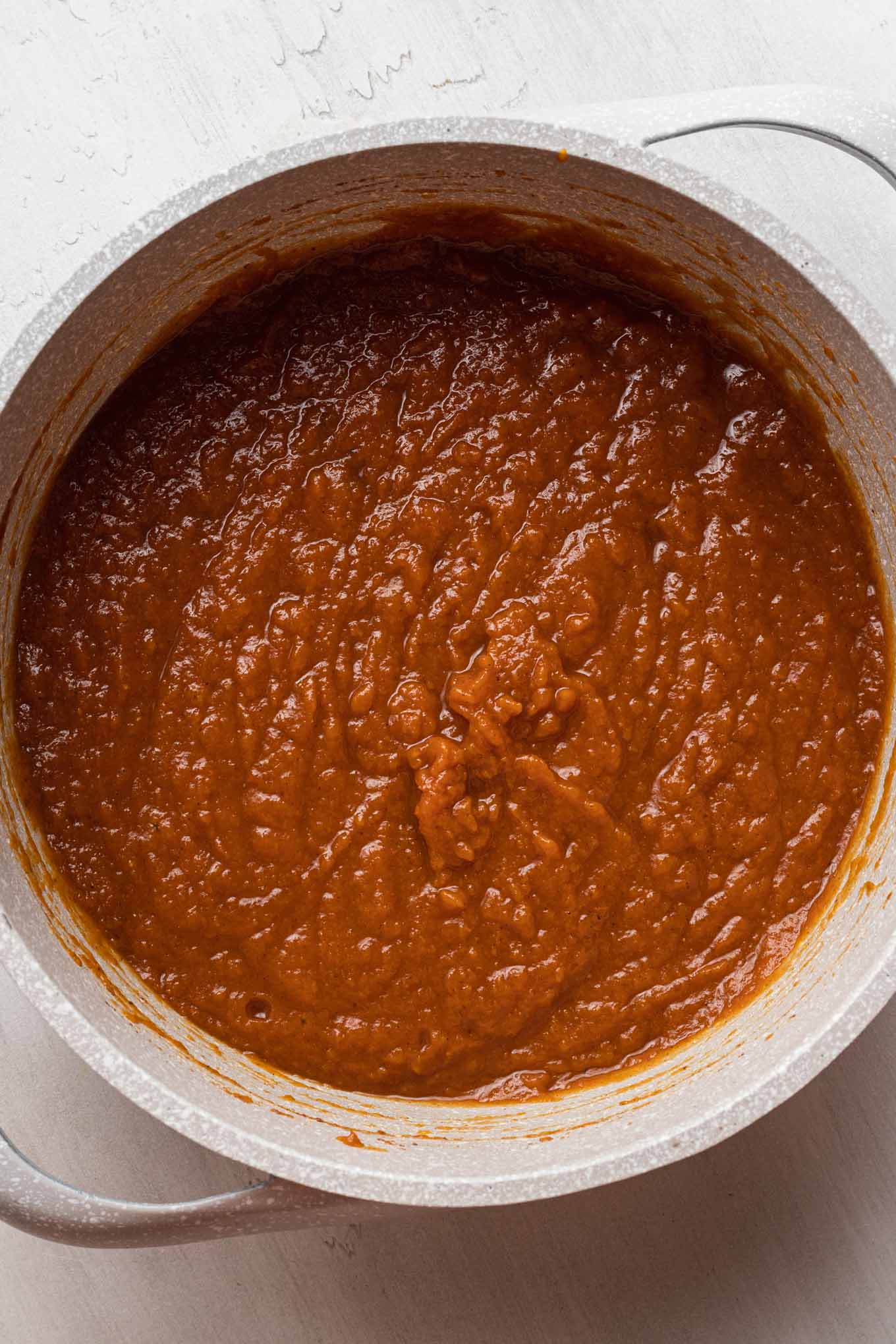 An overhead view of a saucepan filled with pumpkin butter mixture.