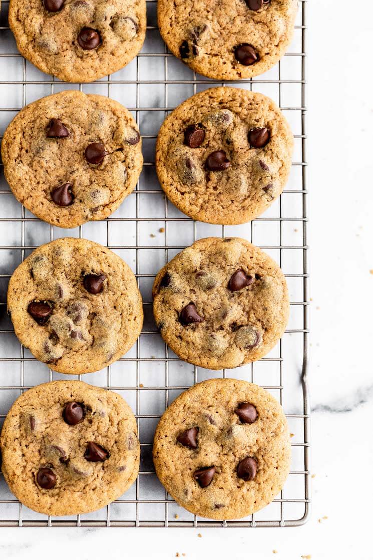 Pumpkin chocolate chip cookies lined up on a wire rack.