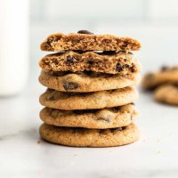 A stack of pumpkin chocolate chip cookies on a marble surface.