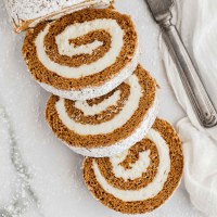 A sliced pumpkin roll dusted with powdered sugar.