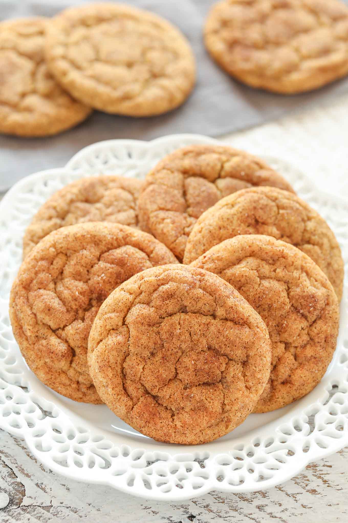 A white plate with six chewy pumpkin cookies. Three more cookies rest in the background. 