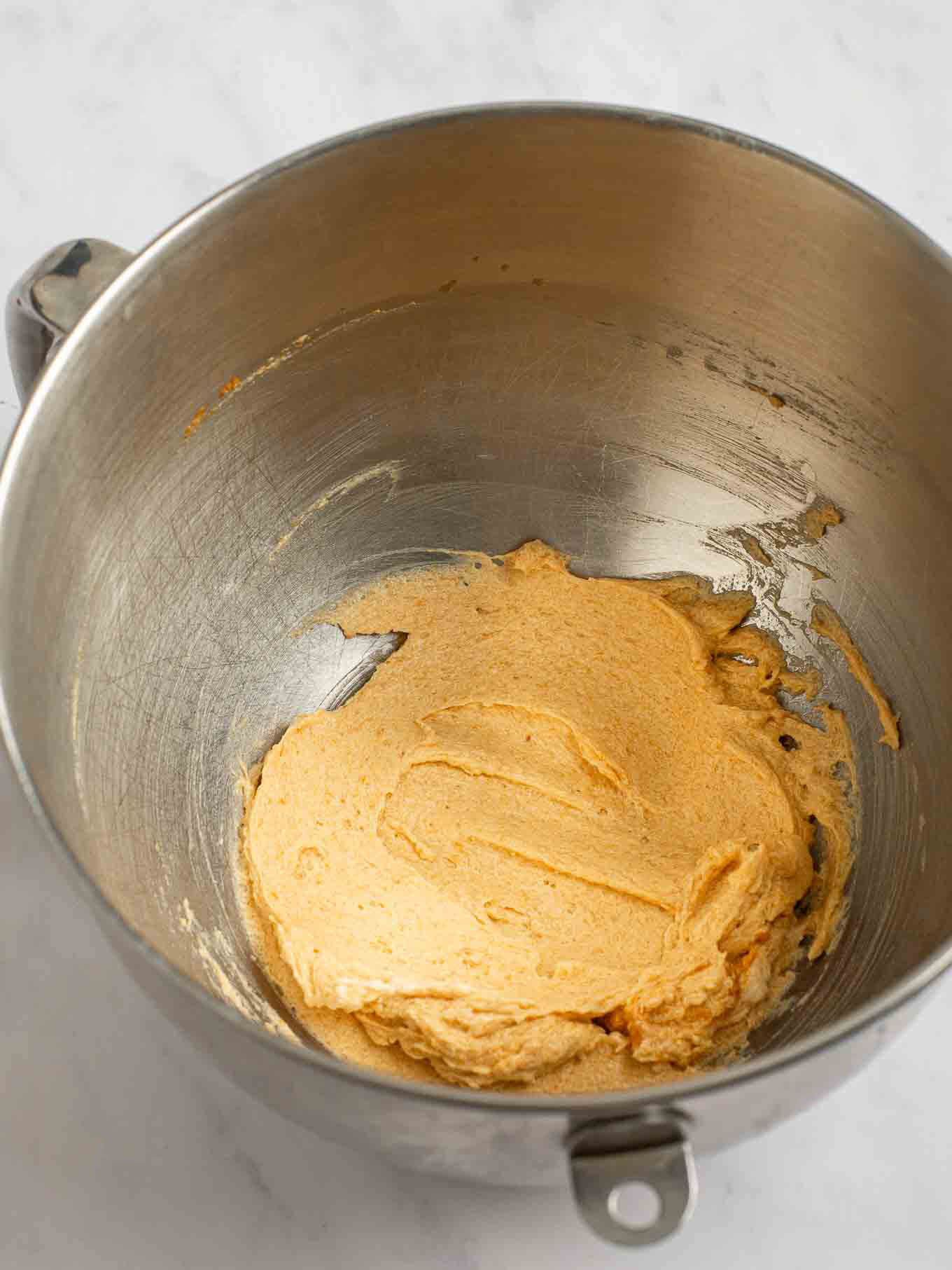 The wet ingredients completely mixed together in the bowl of a stand mixer.