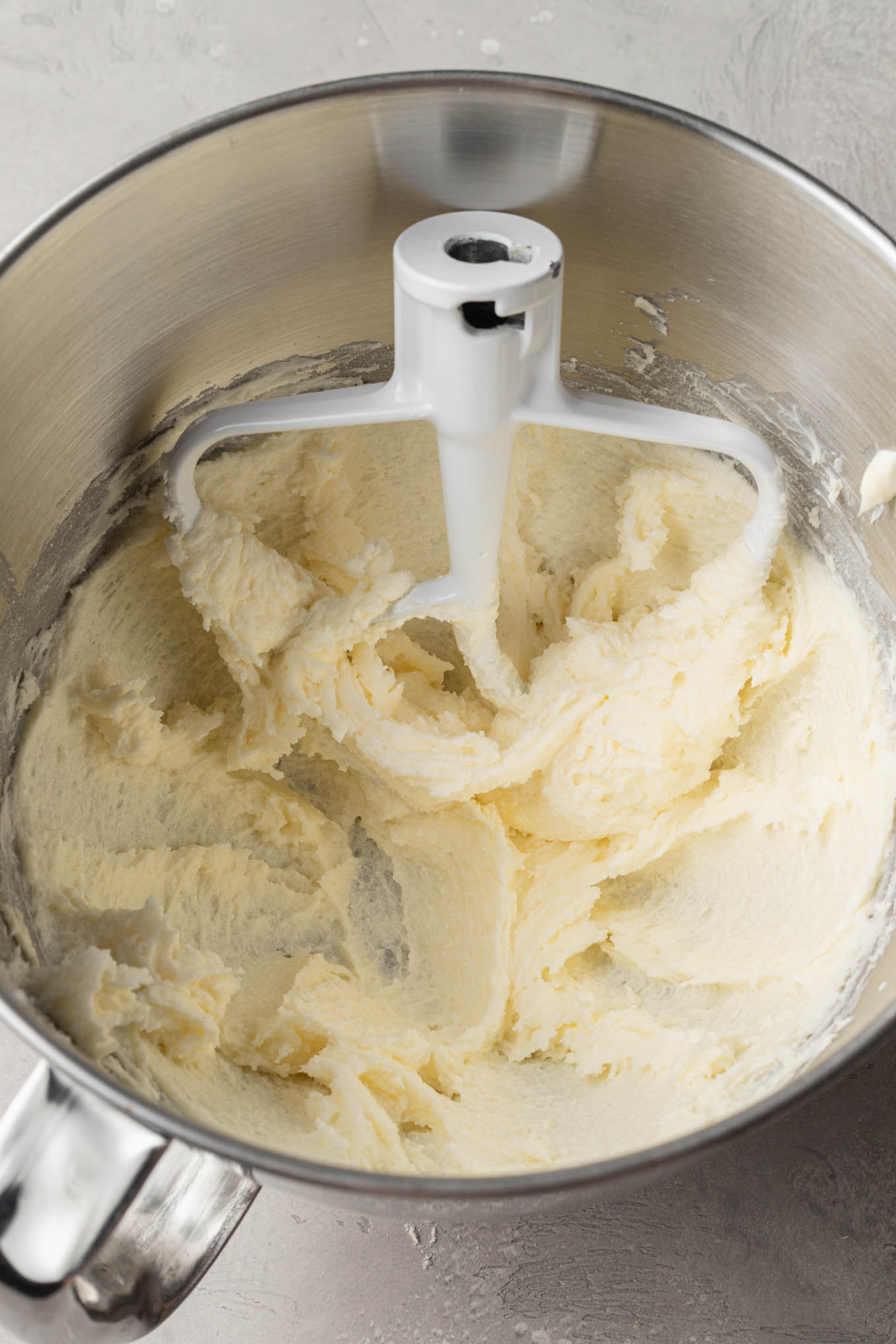 An overhead view of beaten butter and sugar in a stand mixer. 