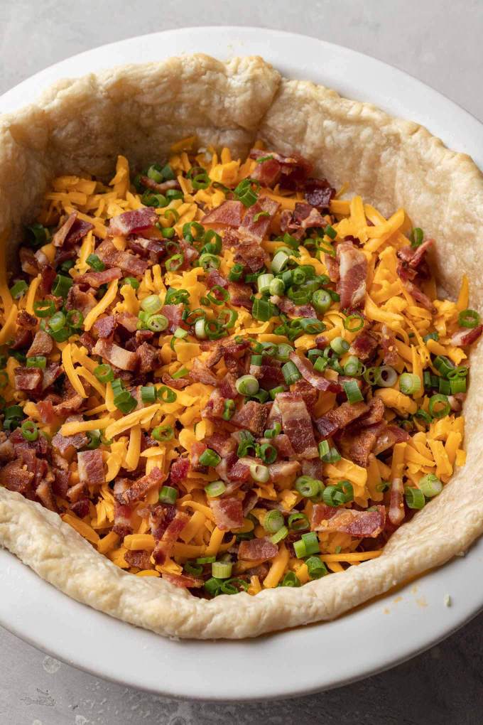 Bacon, chopped green onions, and shredded cheddar sprinkled over a blind baked pie crust.