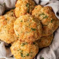 A stack of red lobster biscuits in a bowl lined with a towel.