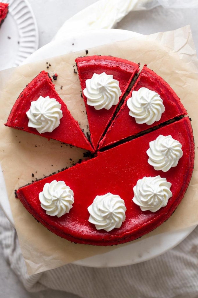 Overhead view of a red velvet Oreo cheesecake that's been partially sliced. 