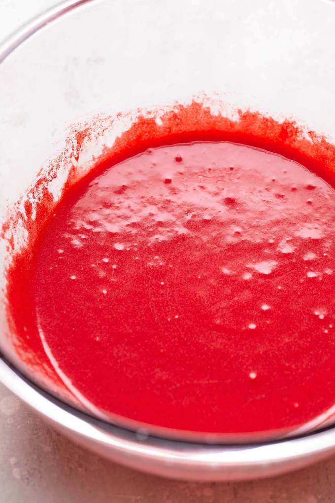 Red velvet cupcake batter in a glass bowl.