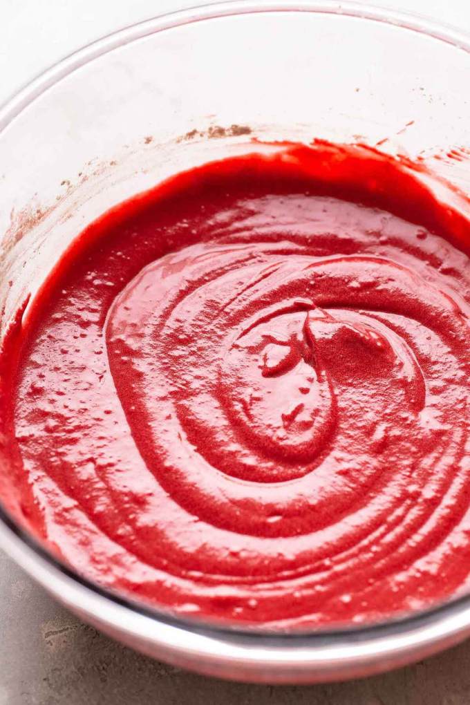 Red velvet cupcake batter in a glass bowl.