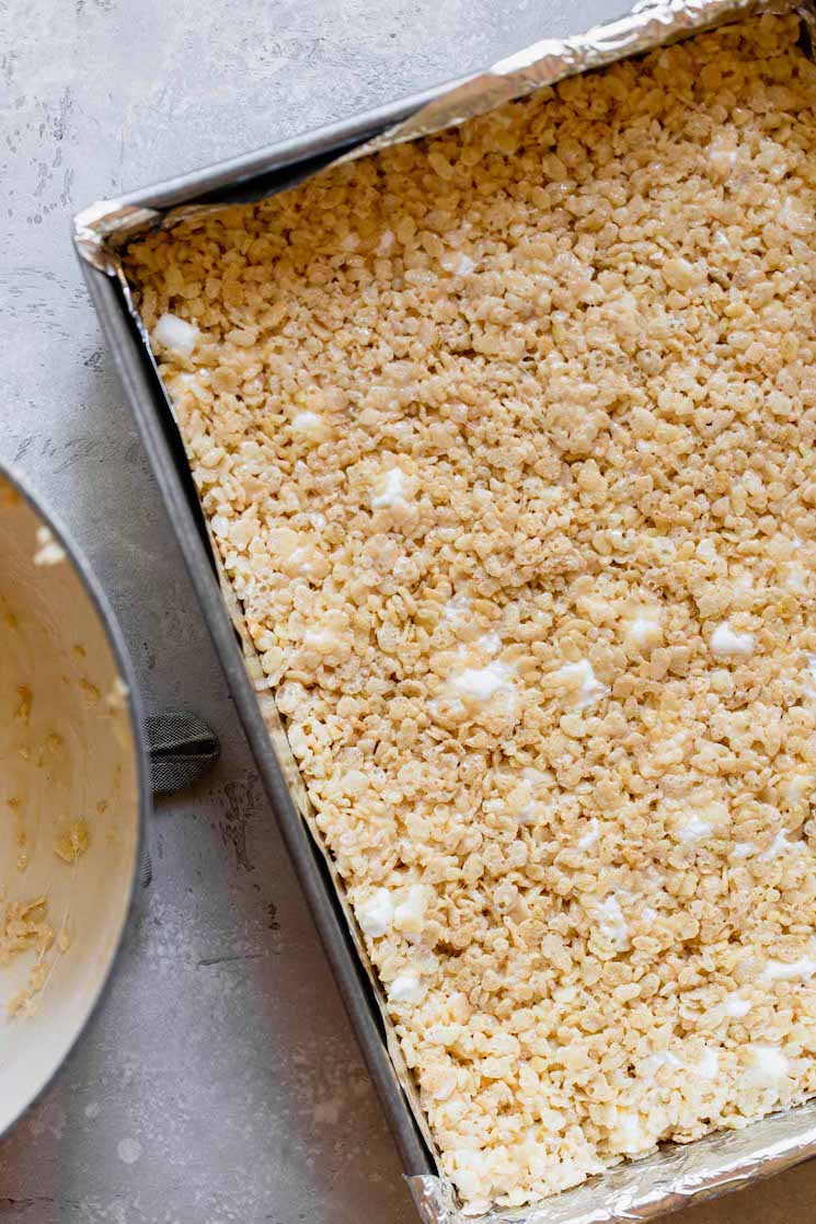 A metal baking pan with the Rice Krispie bar mixture pressed into it. 