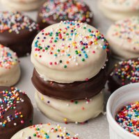 Three ritz cookies coated in white and semisweet chocolate stacked on top of each other.