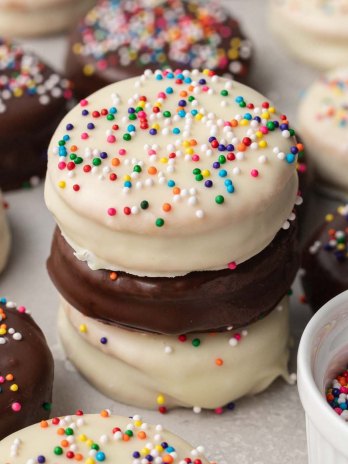 Three ritz cookies coated in white and semisweet chocolate stacked on top of each other.