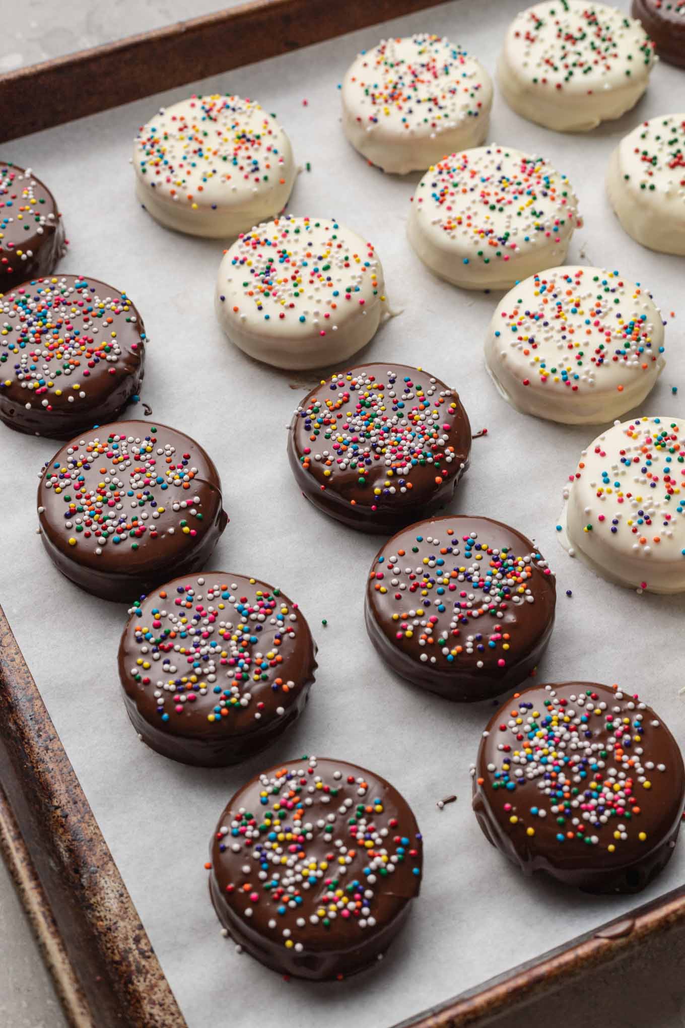 A process short showing rows of chocolate-dipped Ritz cracker cookies on a baking sheet. 