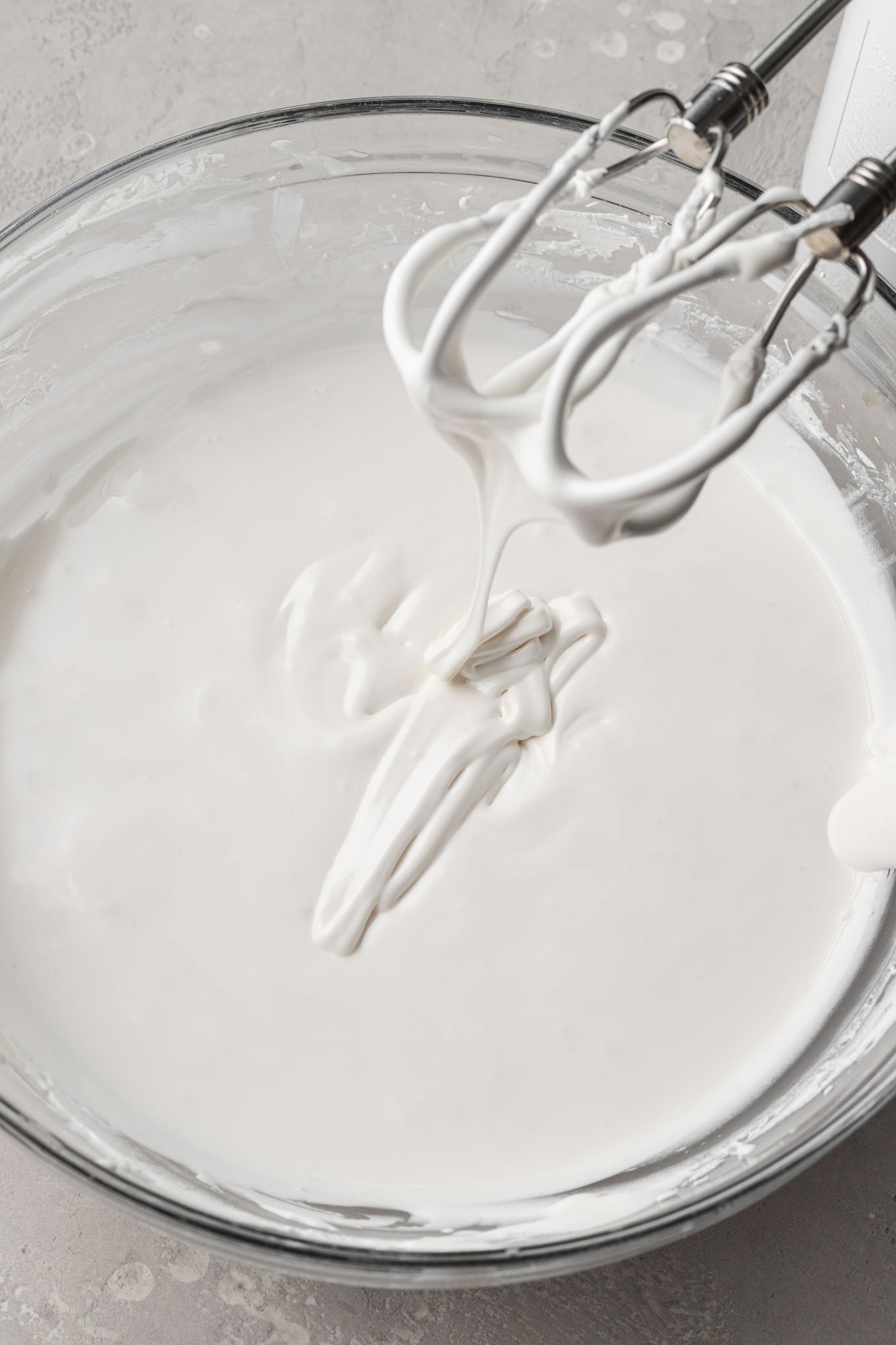 Royal icing that's been thinned to flood consistency in a mixing bowl.