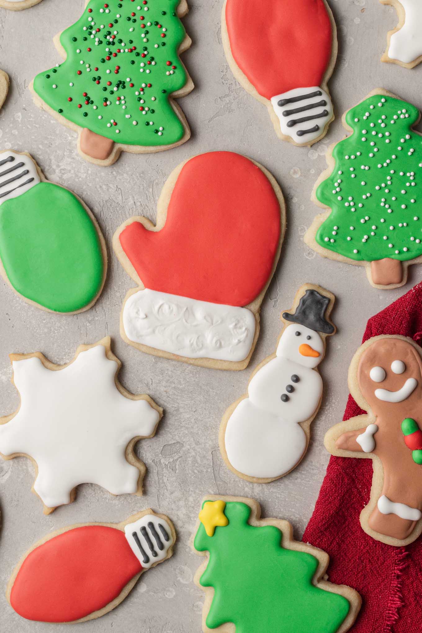 Several Christmas sugar cookies on top of a gray surface.