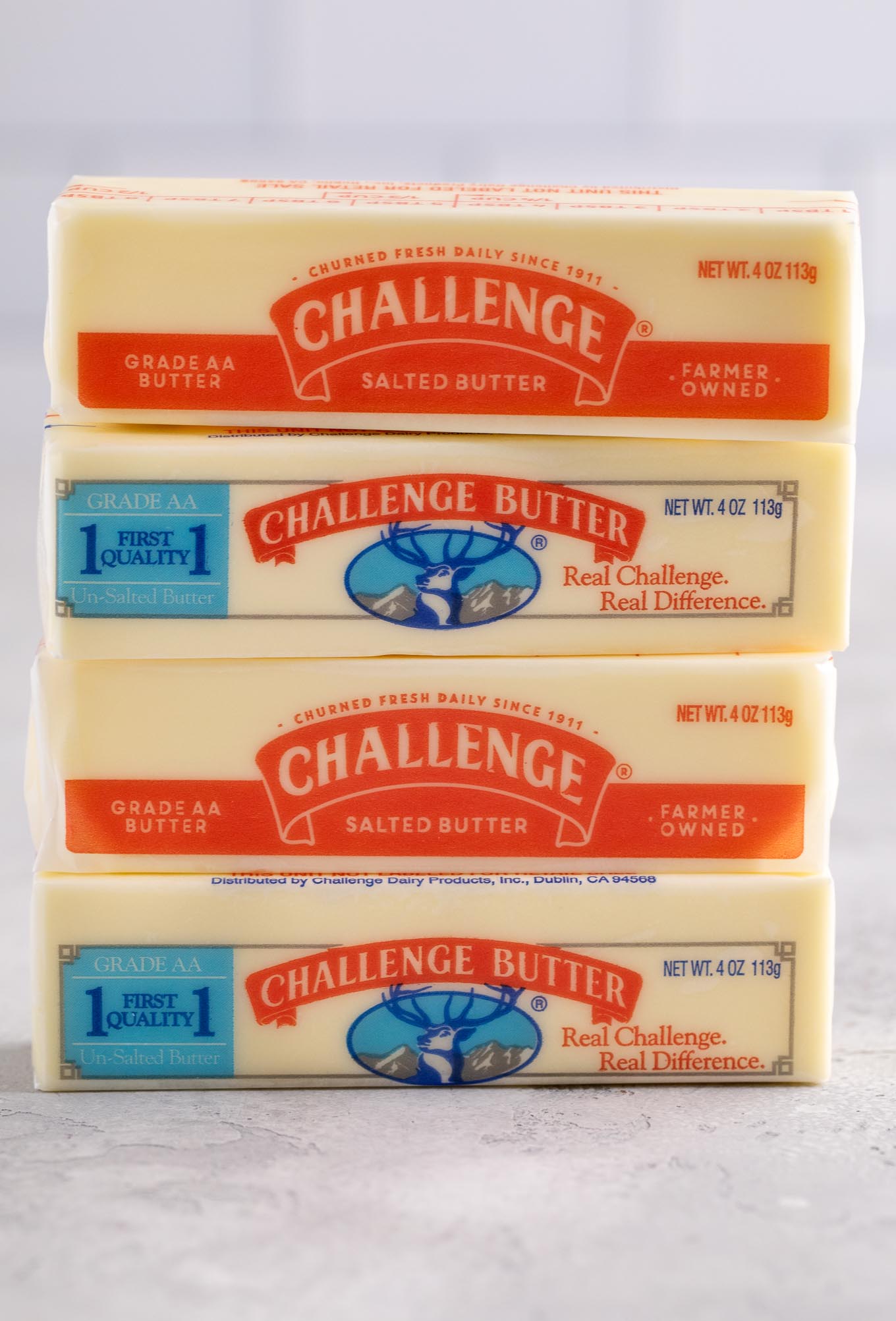 Four sticks of unsalted and salted butter stacked on top of each other.