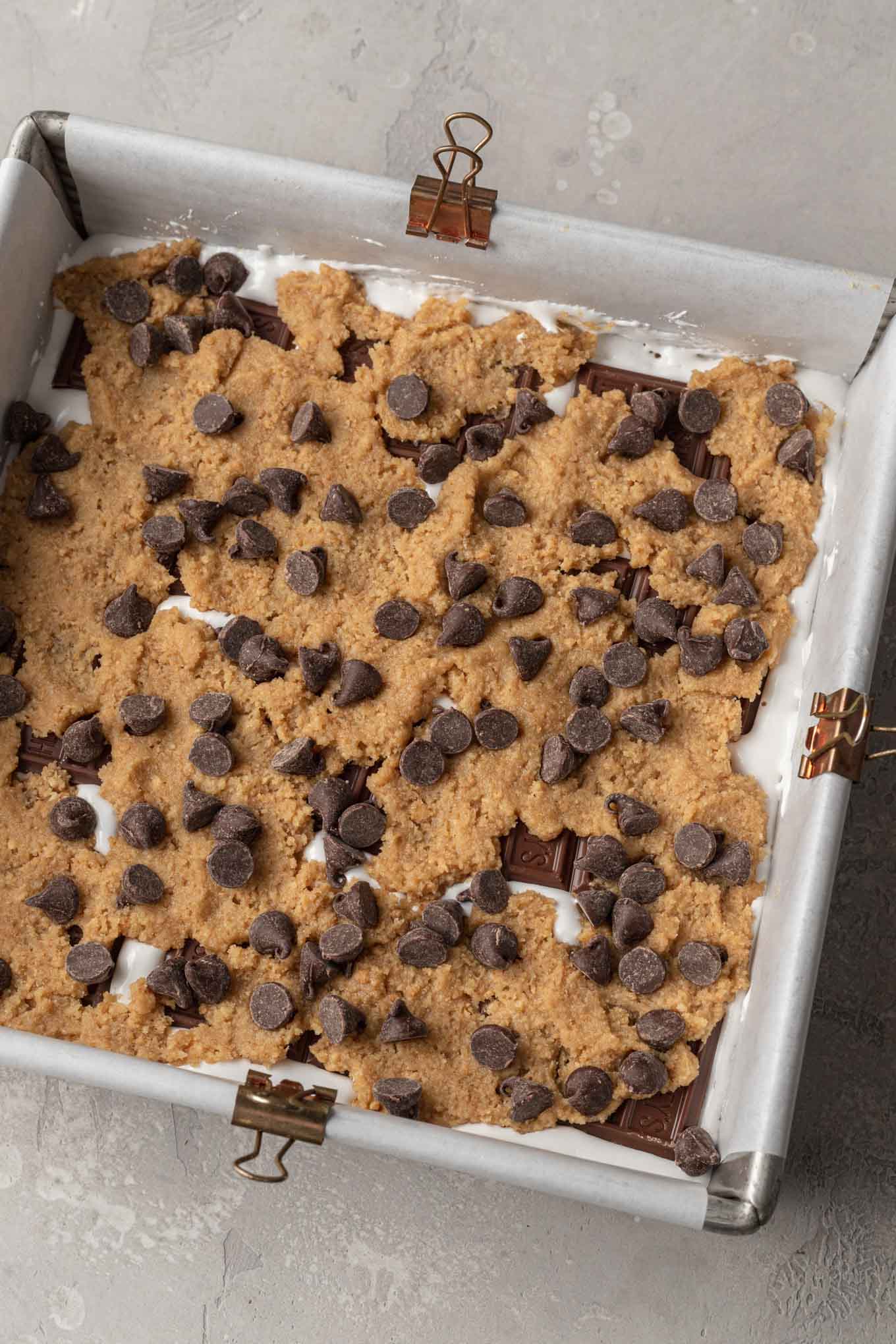 S'mores bars layered in a pan and ready to bake baked.